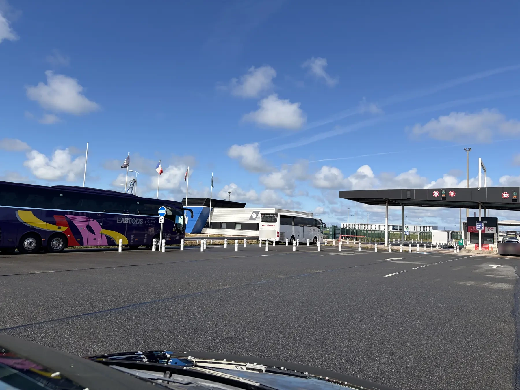 Touringcars bij de incheckloketten van de terminal in Loon-Plage