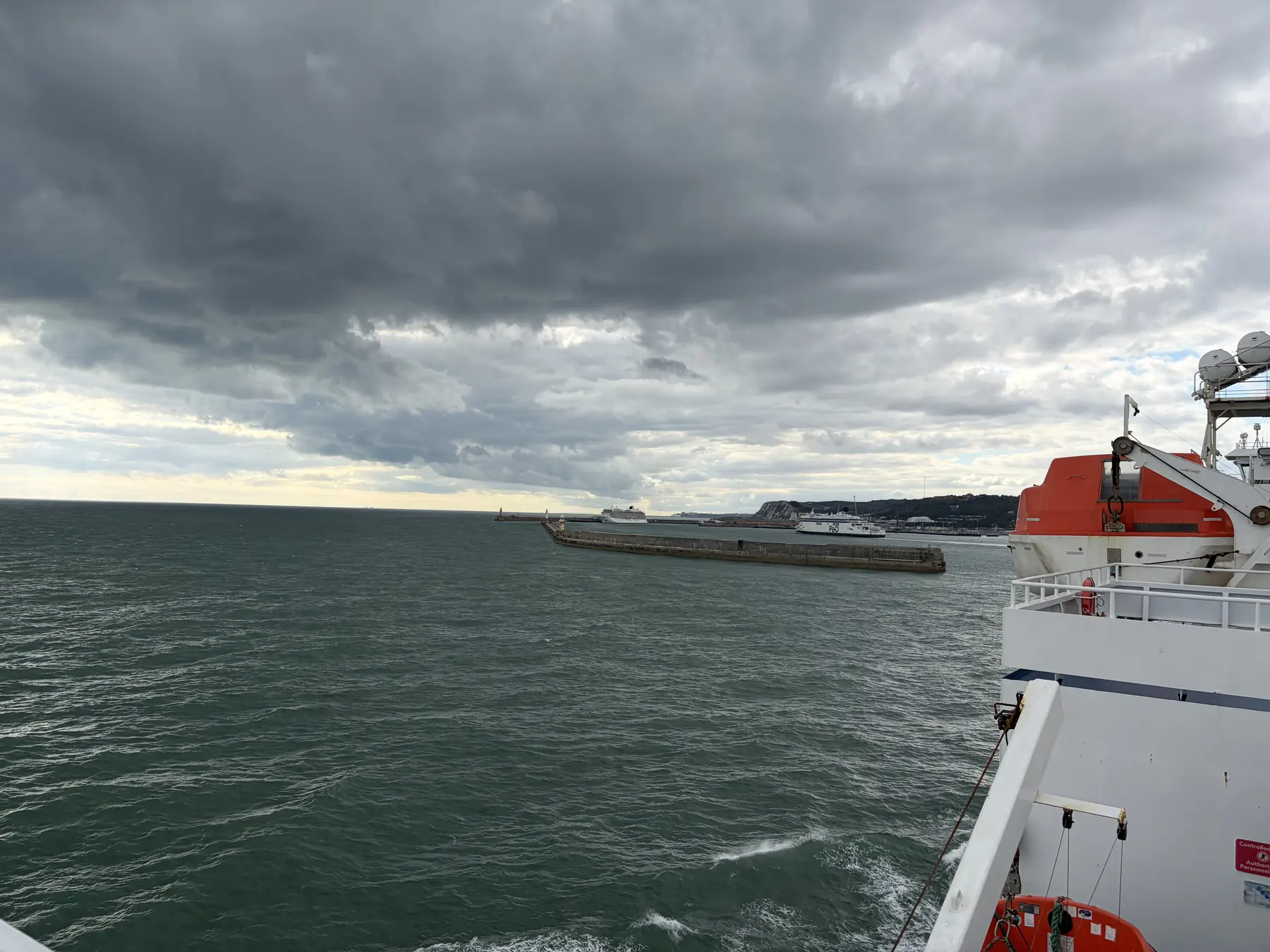 Białe klify Dover pod ciemnymi chmurami, widziane z promu