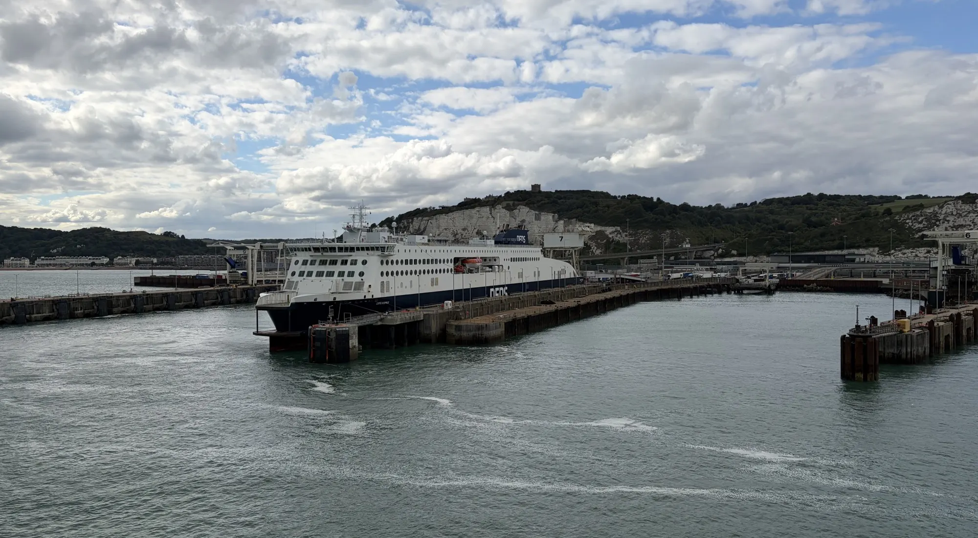 The ferry entering Dover harbour, with the White Cliffs behind the breakwater