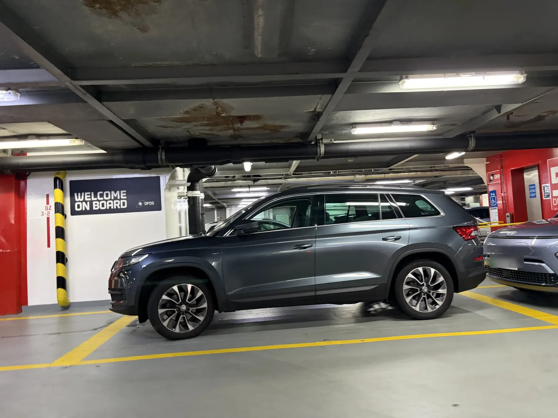 Cars parked closely on the car deck by the Welcome on board sign