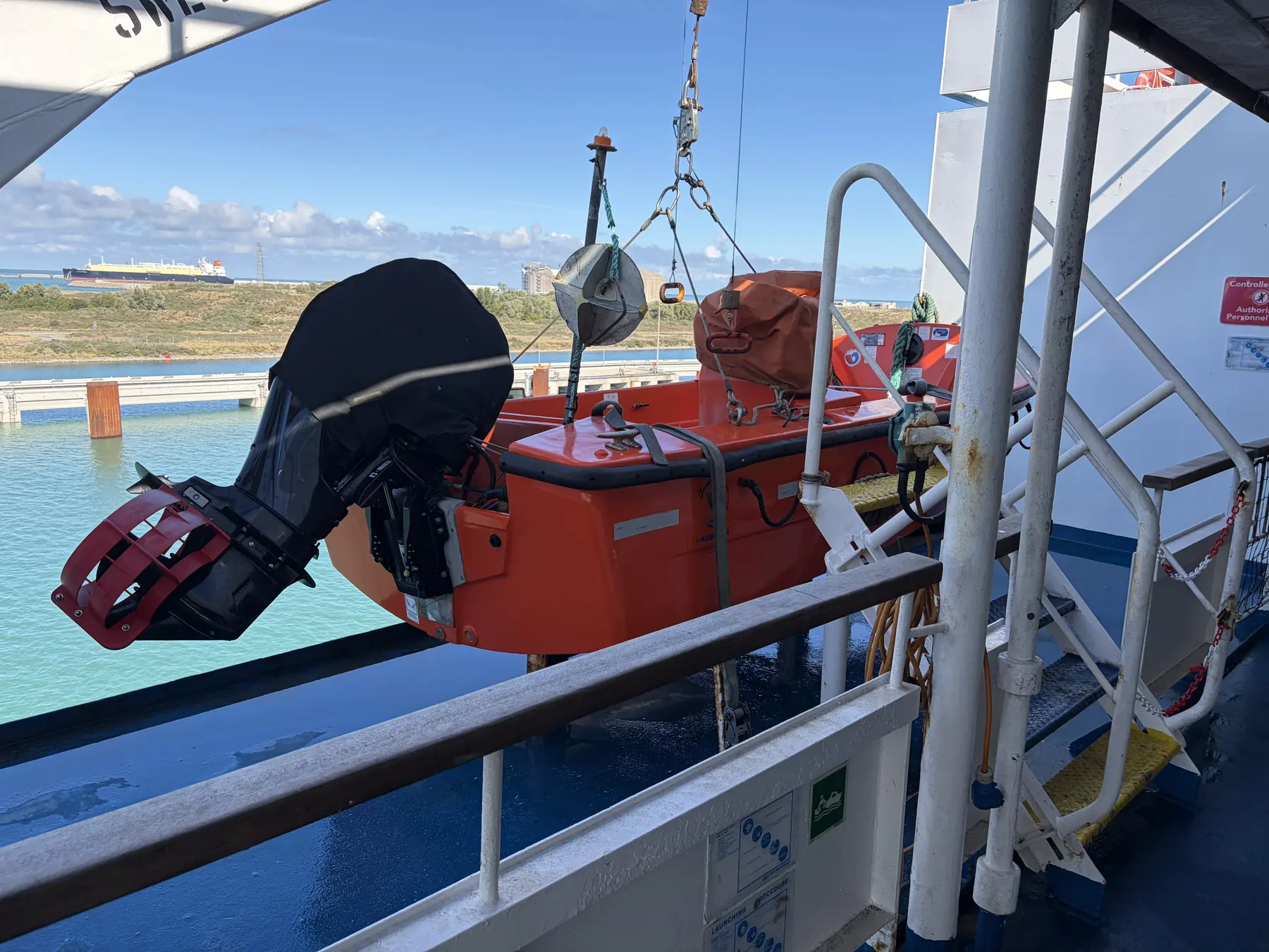 Orange lifeboat and the deck of the Delft Seaways leaving Dunkirk